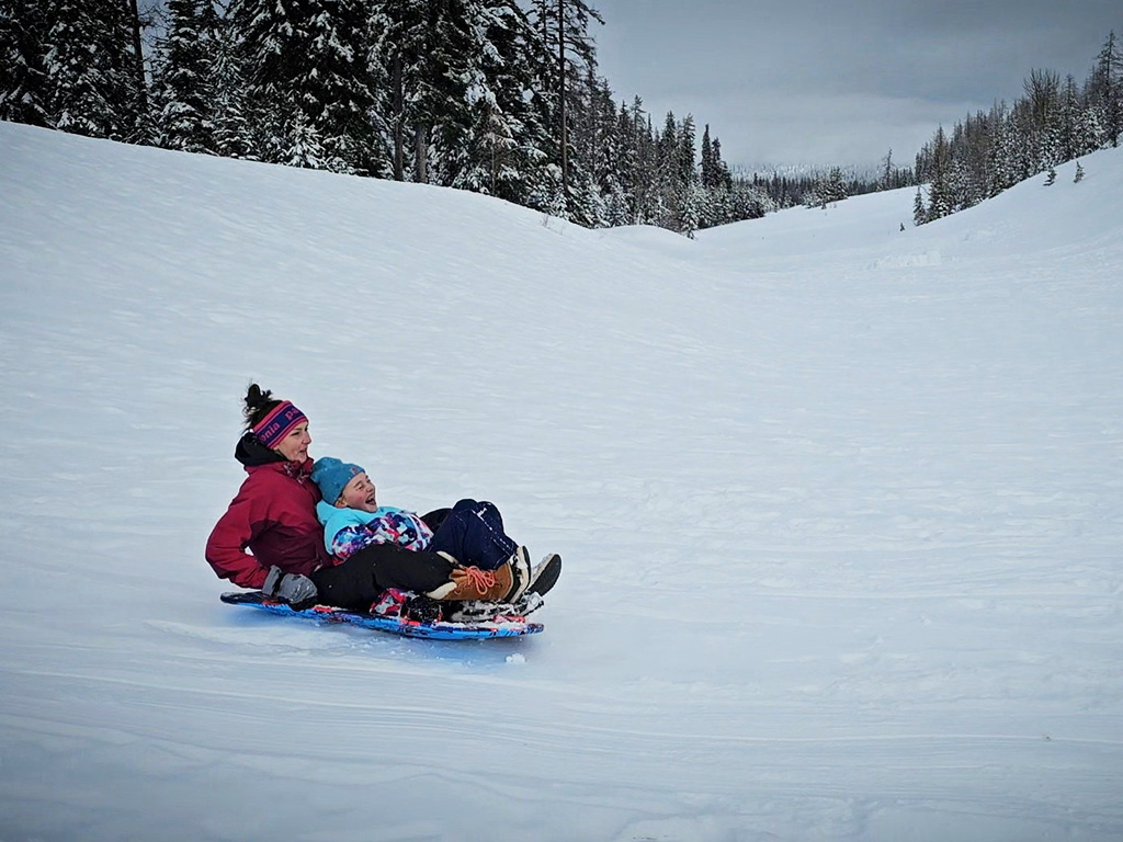 Family fun at Andies Prairie sno-park, a mom and daughter double up on a sled ride.