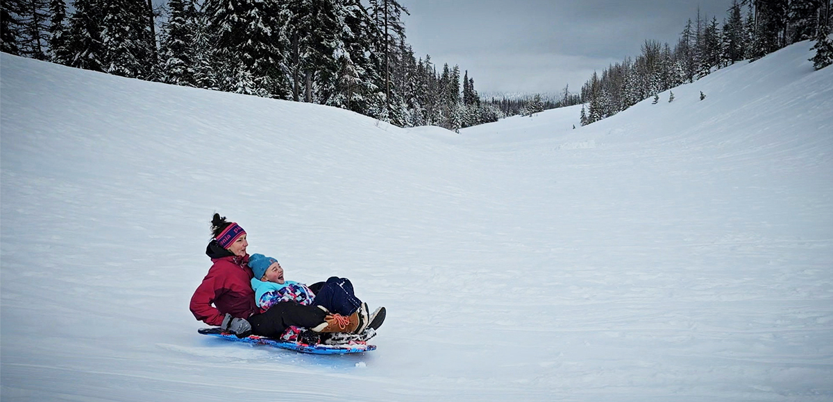 Family fun at Andies Prairie sno-park, a mom and daughter double up on a sled ride.